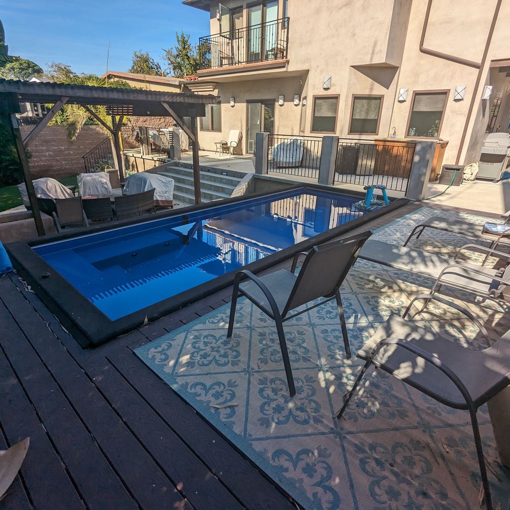 Plunge pool under a pergola with patio seating
